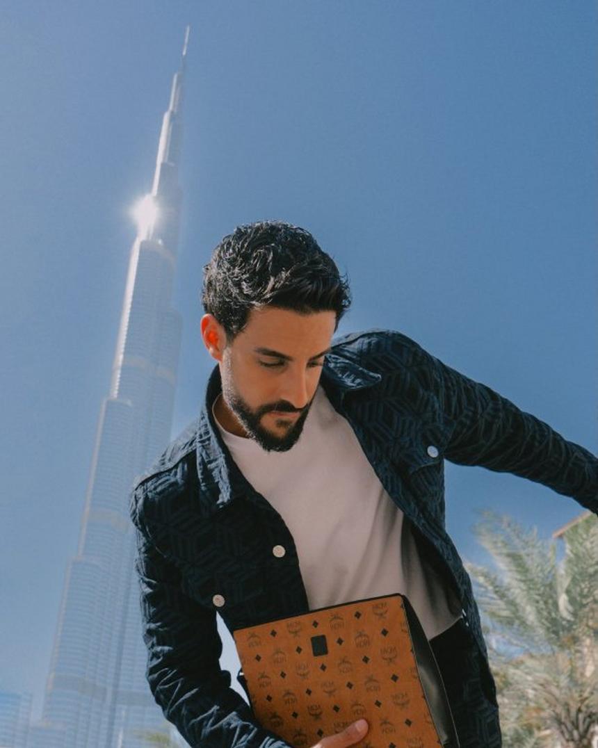 Male influencer dressed in MCM Jean Jacket holding a Visetos Pouch 